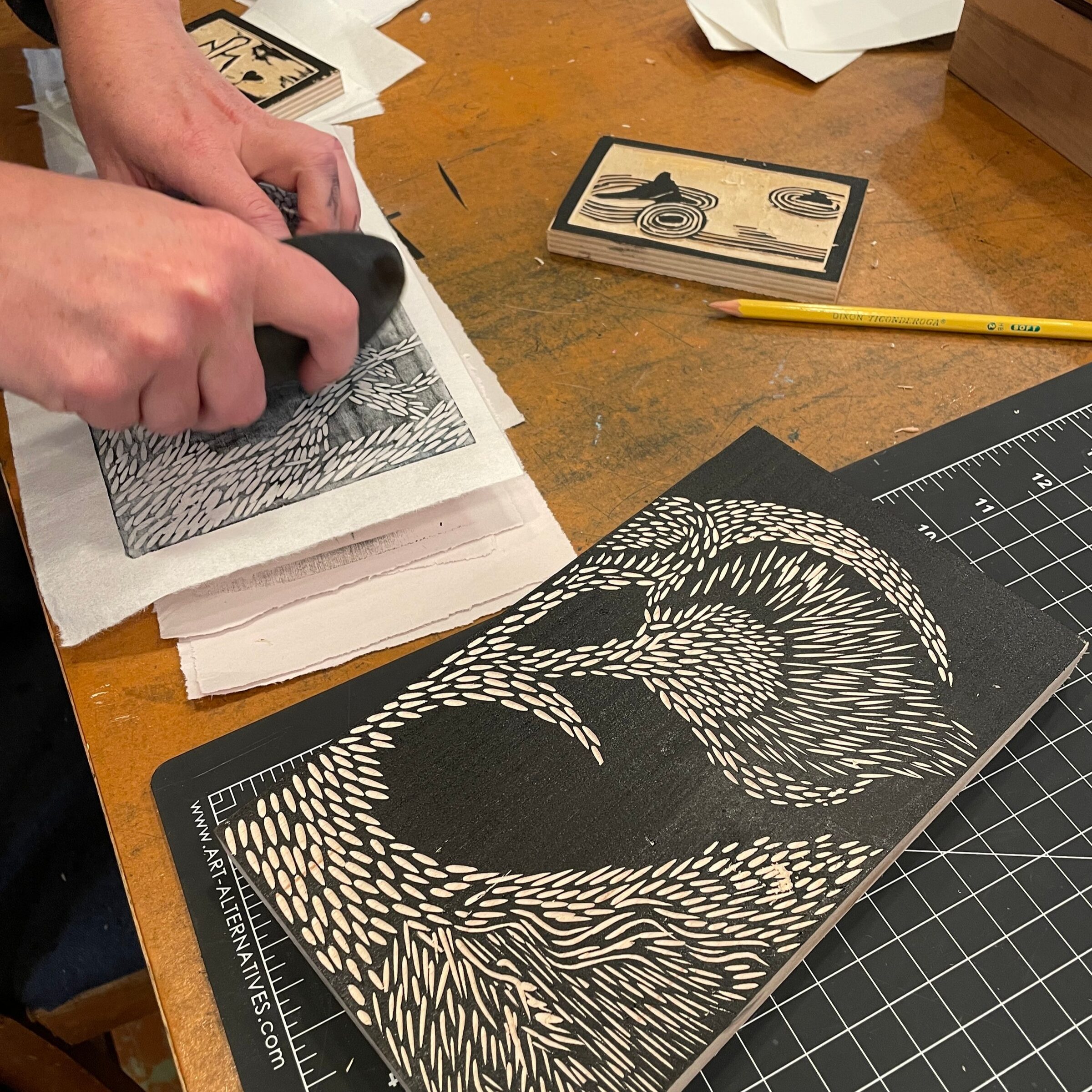 Hands carving a linoleum block